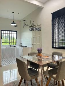 a dining room with a table and chairs and a kitchen at The LuLas Cottage in Malacca