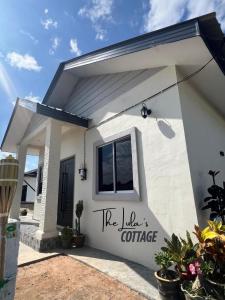 a white house with the lake cottage written on it at The LuLas Cottage in Malacca