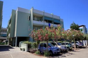 Un estacionamiento con autos estacionados frente a un edificio. en Bilocale Delle Robinie in Baia Verde, en Baia Verde