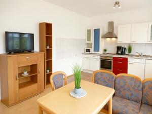 a kitchen with a table and chairs and a television at SUNNYHOME Monteurwohnungen und Apartments in Schwandorf in Schwandorf in Bayern