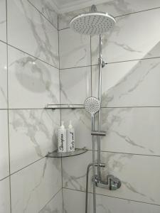 prysznic w łazience z białymi kafelkami w obiekcie Blue North Luxury Apartment w mieście Limenas