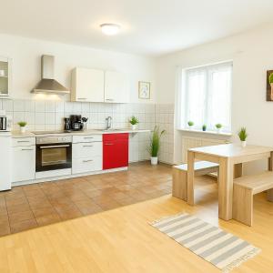 a kitchen with white cabinets and a table in it at SUNNYHOME Monteurwohnungen und Apartments in Schwandorf in Schwandorf in Bayern