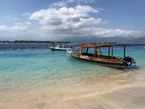 two boats are docked on a beach in the water at Breeze Home BnB in Prampuan