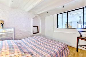 a white bedroom with a bed and a window at Atelier Bleu Charmant petit Loft in Clichy