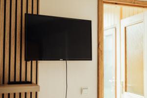 a flat screen tv hanging on a wall at Brakši Namiņš in Pērkone