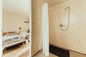a bedroom with a shower and a bed at Brakši Namiņš in Pērkone +61 photos