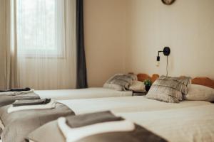 a room with three beds and a window at Brakši Namiņš in Pērkone