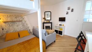 ein Wohnzimmer mit einer Couch und einem Spiegel in der Unterkunft Studio du 104 in Saint-Jean-de-Monts