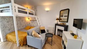 ein kleines Schlafzimmer mit einem Etagenbett und einem Sofa in der Unterkunft Studio du 104 in Saint-Jean-de-Monts