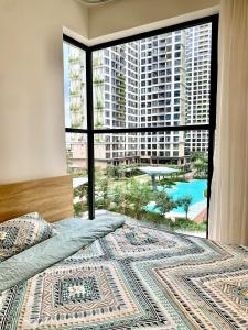 une chambre avec une grande fenêtre avec vue sur une ville dans l'établissement Lumiere 2BR view Garden Pool with Free Gym Swimming, à Gò Công
