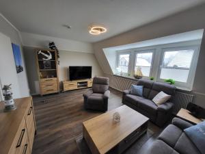 a living room with two couches and a tv at Ferienwohnung Lillian in Bad Zwischenahn