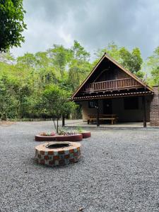 a building with a bench and flowers in front of it at Pousada Canto dos Passáros in Timbe do Sul