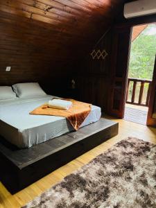 a bedroom with a bed in a room with a rug at Pousada Canto dos Passáros in Timbe do Sul