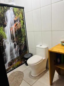 a bathroom with a toilet in front of a waterfall at Pousada Canto dos Passáros in Timbe do Sul +29 photos