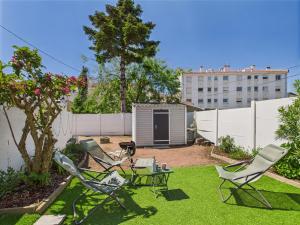 une cour arrière avec des chaises de jardin et un abri de jardin dans l'établissement Entre coeur de ville et plage, maison pour 6, à Saint-Gilles-Croix-de-Vie