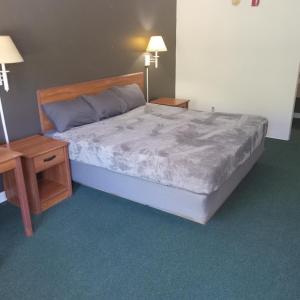a bedroom with a large bed and two night stands at King Bed Hotel Studio 232 in Livingston