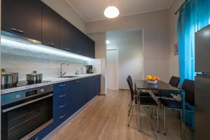 a kitchen with blue cabinets and a dining table at Laki's Place in Chrani