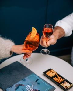 two people holding up two glasses of wine at Hôtel AKENA Chalons-en-Champagne in Châlons-en-Champagne +15 photos