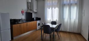 a kitchen with a table and chairs in a kitchen at Pôr do Sol II in Porto Moniz