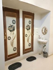 a bathroom with two wooden doors and a sink at Shanker Bhawan Homestay in Gaya +11 photos