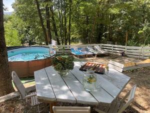 a wooden table with flowers on it next to a pool at Casa Mariei - Vila Breaza in Nistoreşti