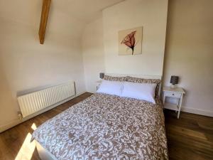 een slaapkamer met een bed en een schilderij aan de muur bij The Trackside Cottage in Carlin How