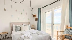 a bedroom with a bed and a large window at Casas da Praia by Sevencollection in Salema