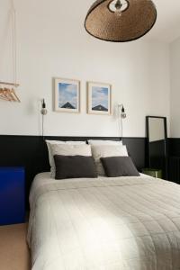a bedroom with a large white bed with a ceiling at Chambre avec salle de bain et accès indépendant in Nantes +12 photos