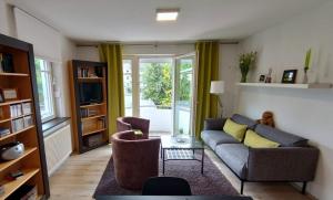 a living room with a couch and chairs and a tv at Maisonettwohnung direkt im Zentrum in Neubrandenburg