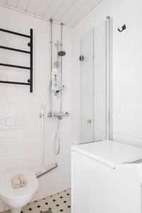 un bagno bianco con doccia e WC di Comfy Top Floor Studio Apt in Centre of Helsinki a Helsinki Altre 21 foto