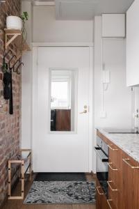 una cucina con porta bianca e finestra di Comfy Top Floor Studio Apt in Centre of Helsinki a Helsinki