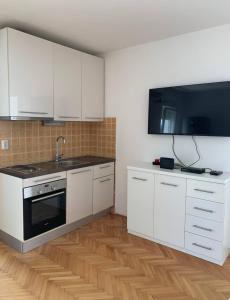 a kitchen with white cabinets and a sink and a stove at Sunny in Split