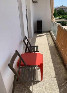 a red table and a chair on a balcony at Sunny in Split
