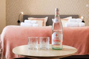 a bottle and two glasses on a table in a bedroom at Hotel La Casa in Valkenburg