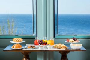 a table with plates of food on it next to a window at Villa Raffaella in Santa Cesarea Terme
