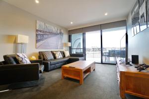 a living room with a couch and a coffee table at Prestige Waterfront Apartment in Kingston, ACT in Canberra