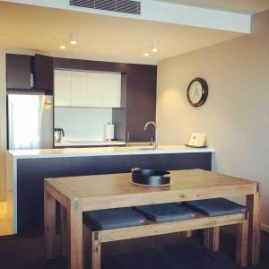 a kitchen with a wooden table and a sink at Prestige Waterfront Apartment in Kingston, ACT in Canberra