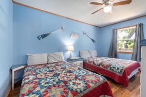 two beds in a room with blue walls and a window at Artilla Cove Cabin 6 -Lake views- Pool & Hot Tub in Branson