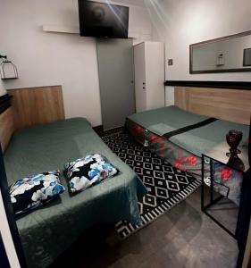 a room with two beds and a tv on the wall at Noclegi 2 pokoje in Szczecinek