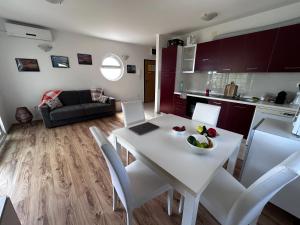 a kitchen and living room with a white table and chairs at Apartment Milna Dante in Milna
