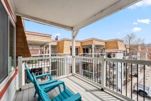 a balcony with two blue chairs on a house at Main St Condo with Fireplace & Mountain Views in Breckenridge