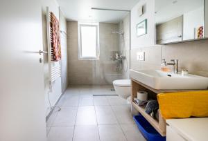 a white bathroom with a sink and a toilet at Dingqin'Home in Arni Alp