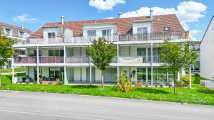 an apartment building with a balcony and trees at Dingqin'Home in Arni Alp