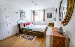 a bedroom with a bed and a table and a mirror at Dingqin'Home in Arni Alp