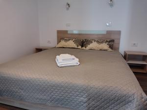 a bed with a white towel on top of it at Unique apartments in Timişoara