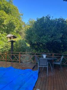 a deck with a table and chairs and a bird feeder at Casa próximo parque de eventos com piscina aquecida na temporada in Bento Gonçalves