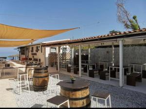 eine Terrasse mit Tischen und Stühlen und ein Gebäude in der Unterkunft Villa VAdel Zambrone Marina in Zambrone