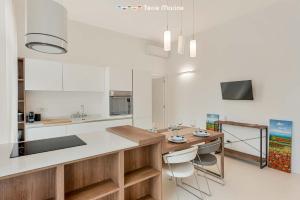 a kitchen with white cabinets and a table and chairs at Fedora, Terre Marine in La Spezia
