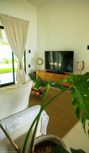 un soggiorno con TV e impianto elettrico di Pipa Sunset Home a Pipa
