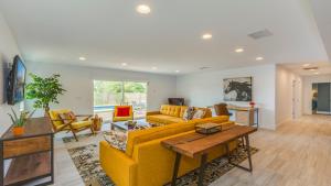 ein Wohnzimmer mit einem gelben Sofa und Stühlen in der Unterkunft F-27 Carnelian in Anaheim